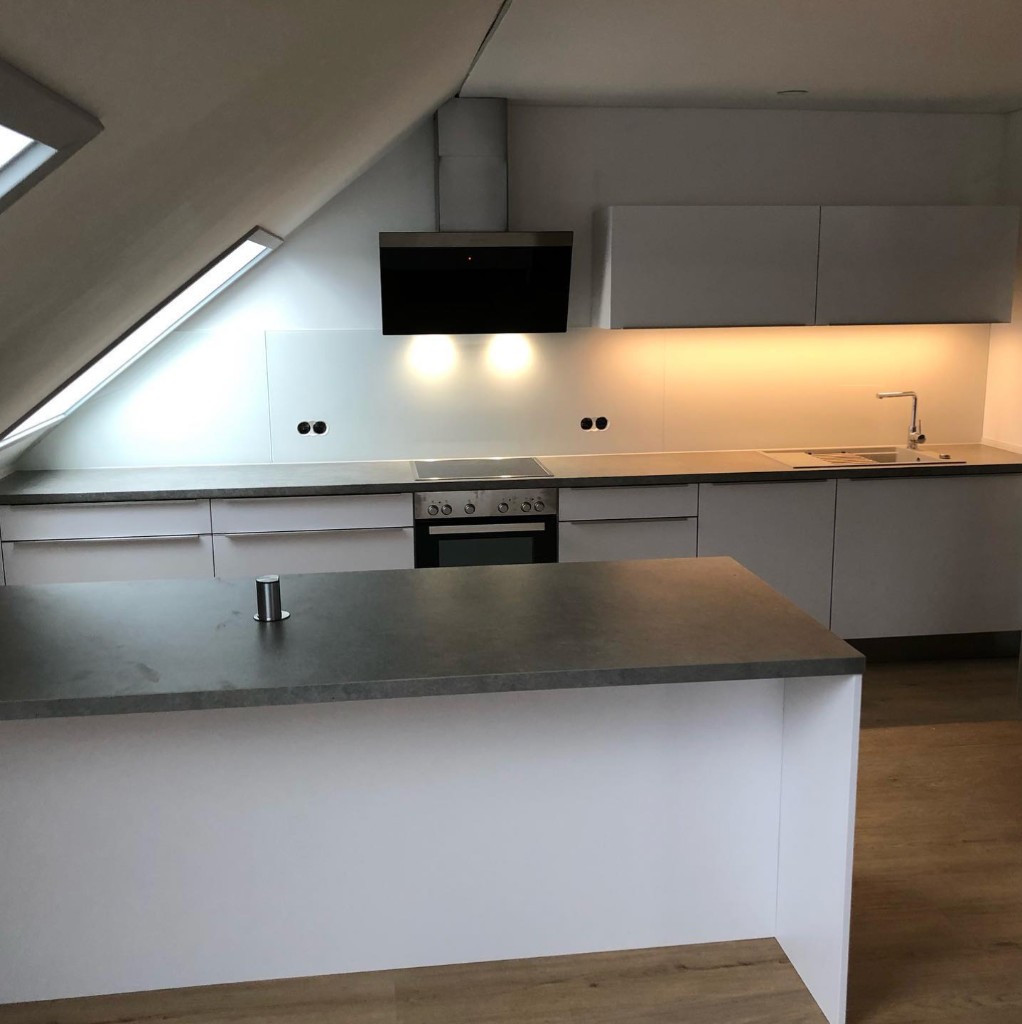 Moderne Dachgeschoss-Küche mit Insel und Griffleisten