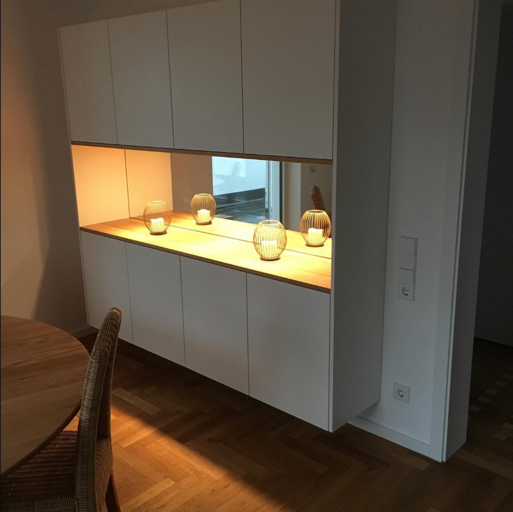 Weißes Sideboard mit beleuchteter Holz-Nische und Spiegel