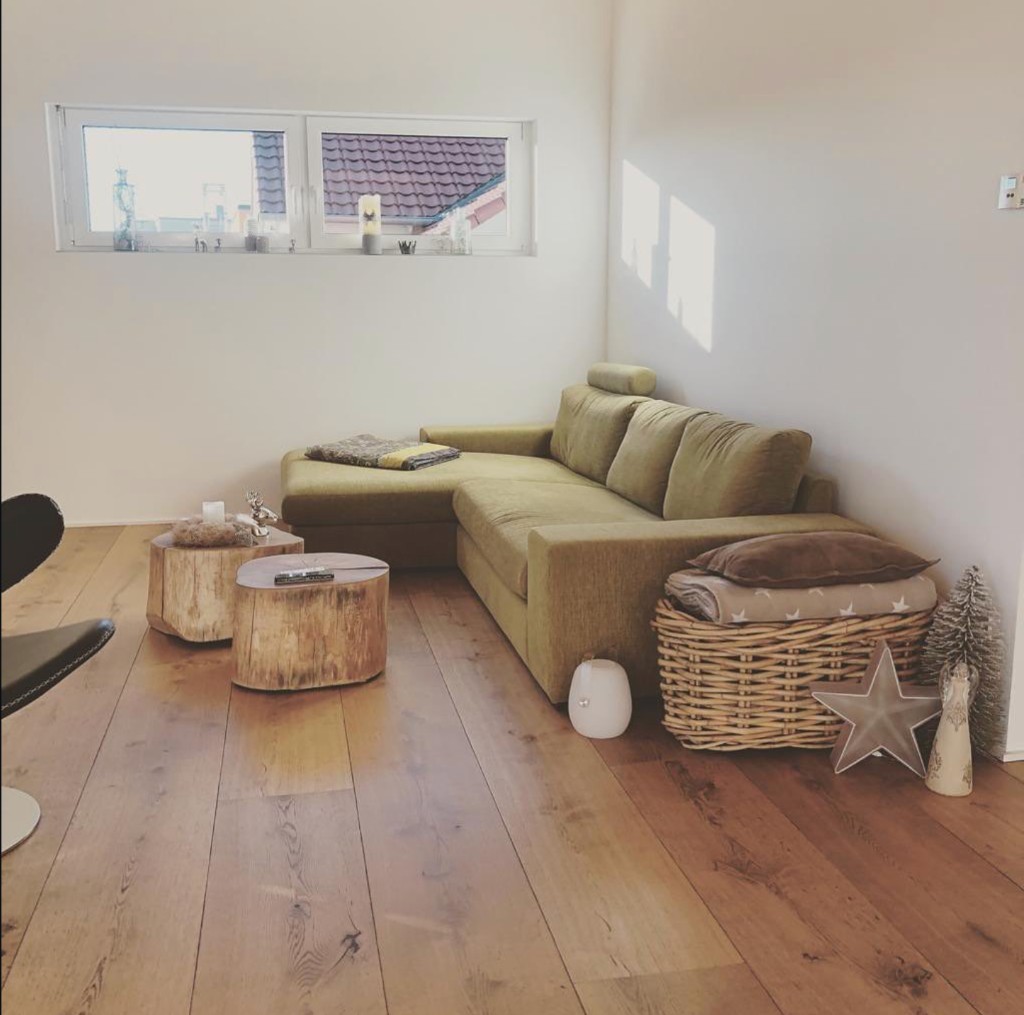 Wohnzimmer mit Holzboden und massiven Baumstamm-Tischen