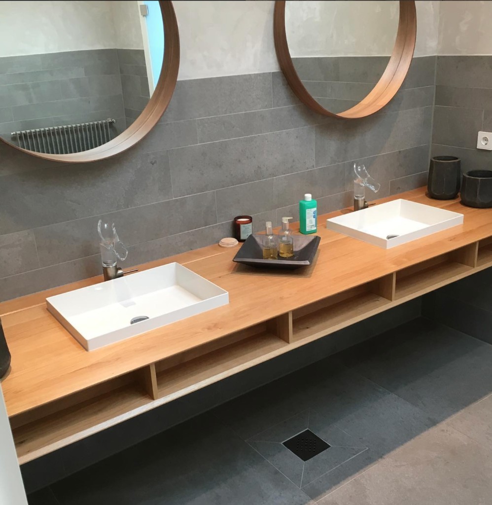 Modernes Bad mit Holzwaschtisch und runden Spiegeln